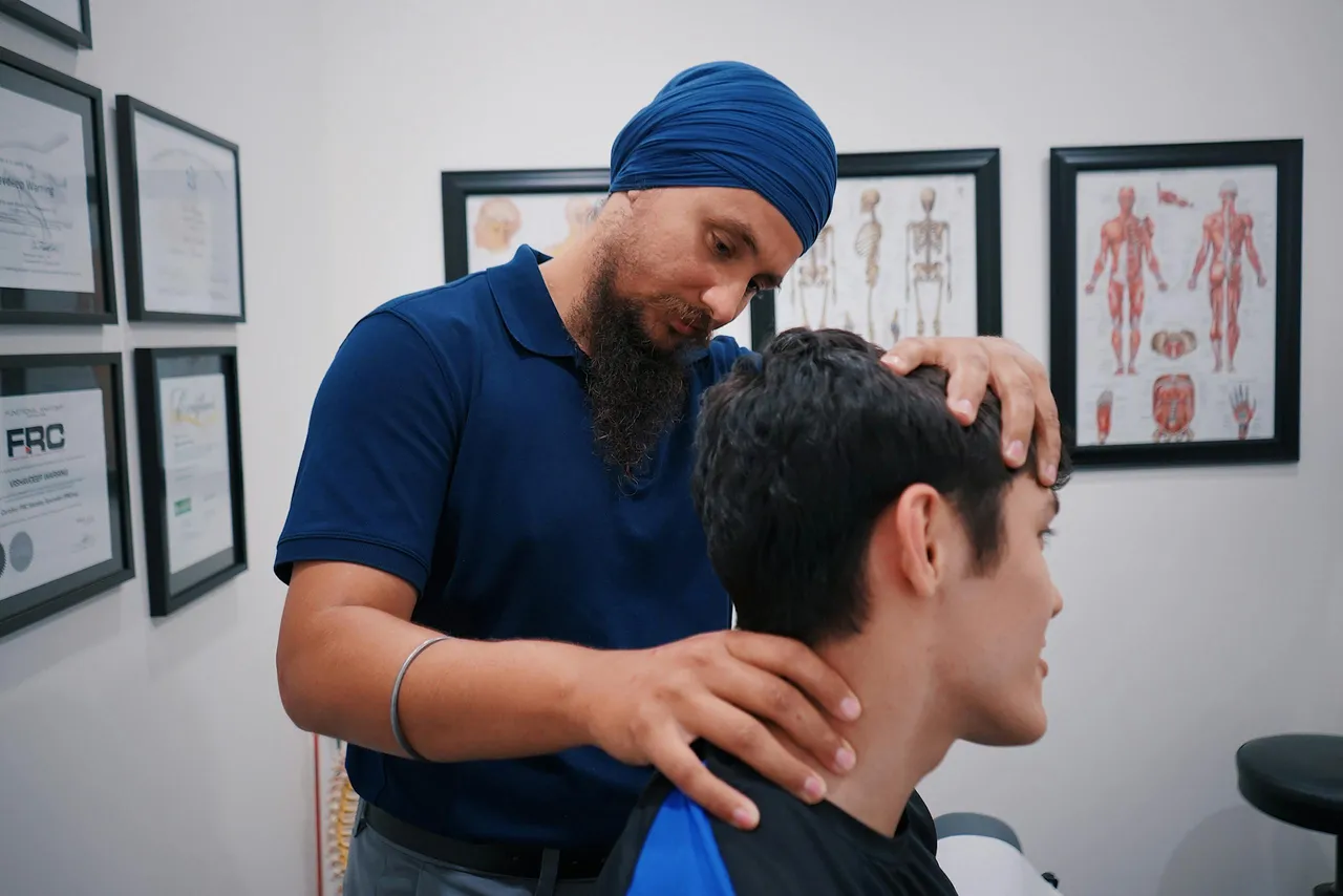 Professional physiotherapist adjusting a patient neck in a clinical treatment room