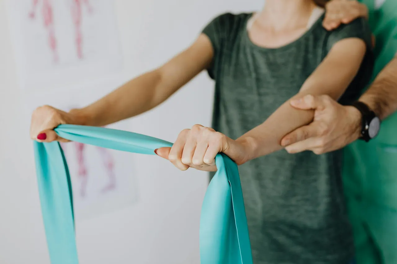 Physical therapist assisting a patient with a core strengthening exercise on a mat
