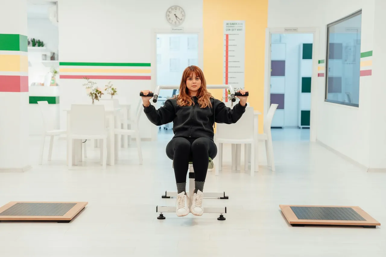 Physical therapist guiding a patient through a back exercise on a mat, demonstrating proper form in a clinical setting.