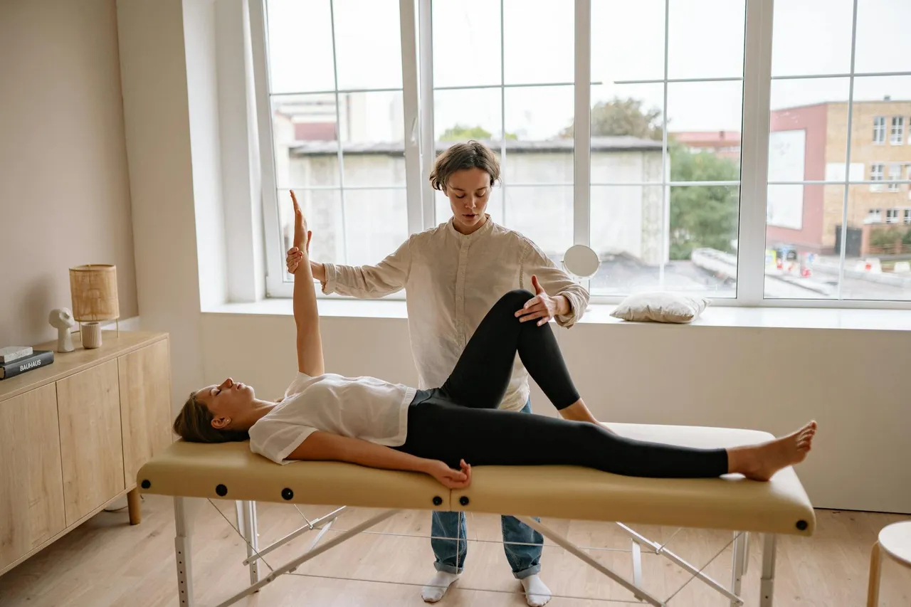 Physical therapist guiding a patient through dynamic leg stretches, demonstrating proper form for injury prevention.
